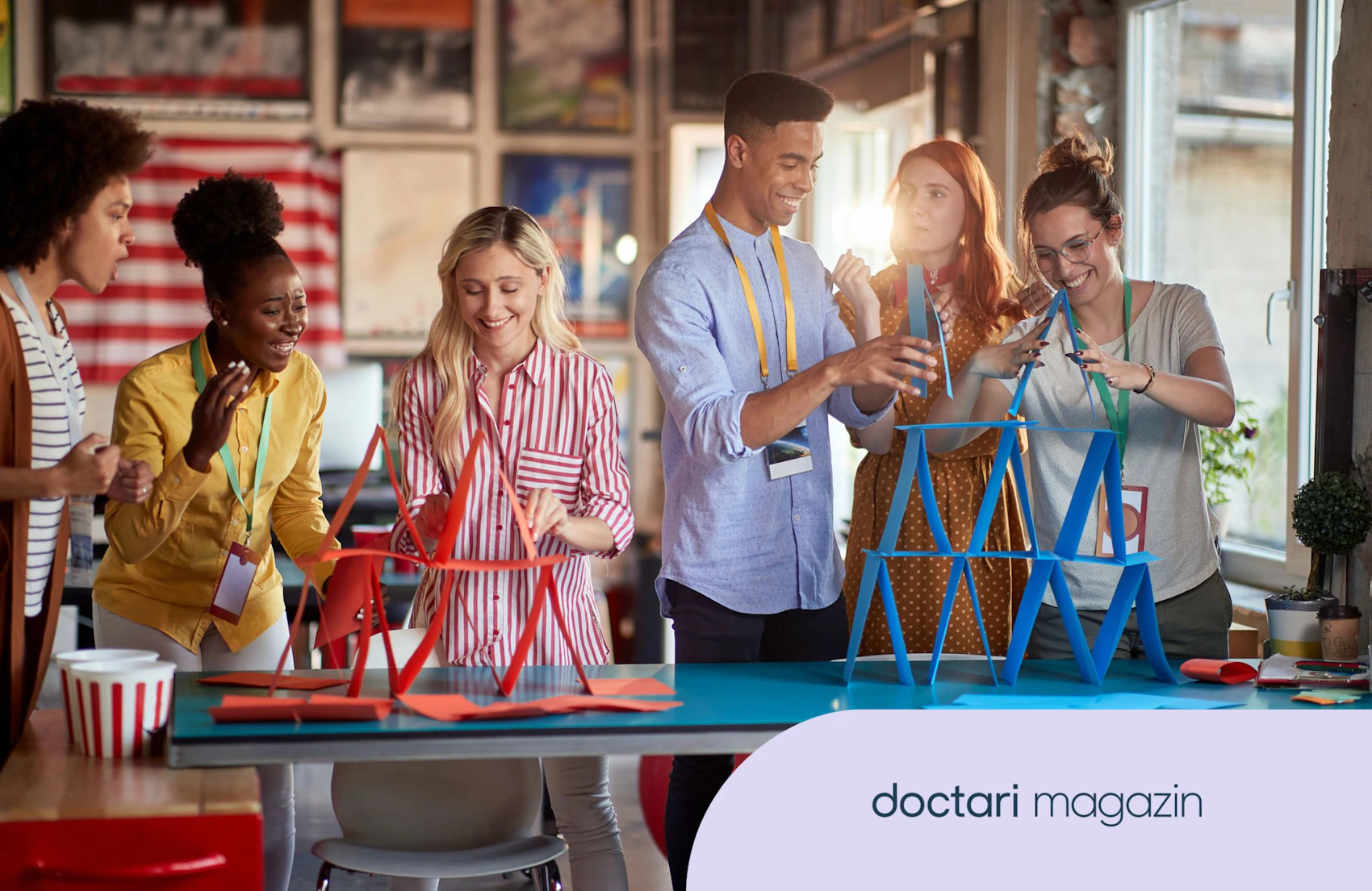 Eine gruppe junger Menschen baut Kartenhäuser