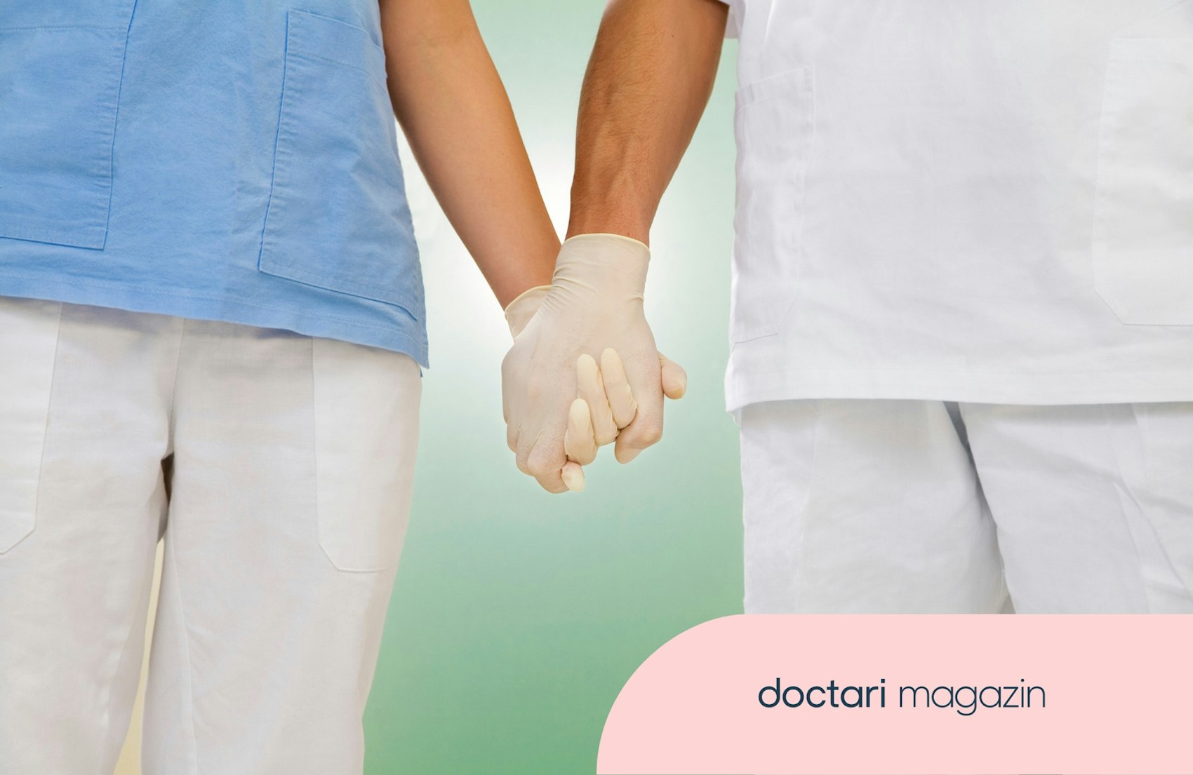 Zwei medizinische Fachkräfte in Arbeitskleidung halten Händchen