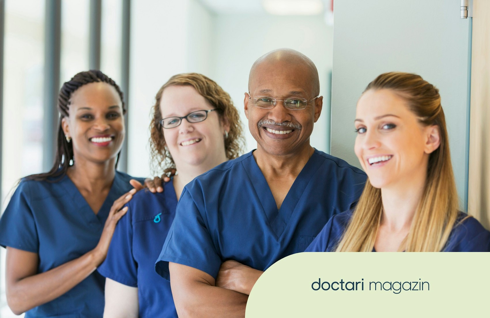 Drei Pflegerinnen und ein Pfleger lächeln in die Kamera.