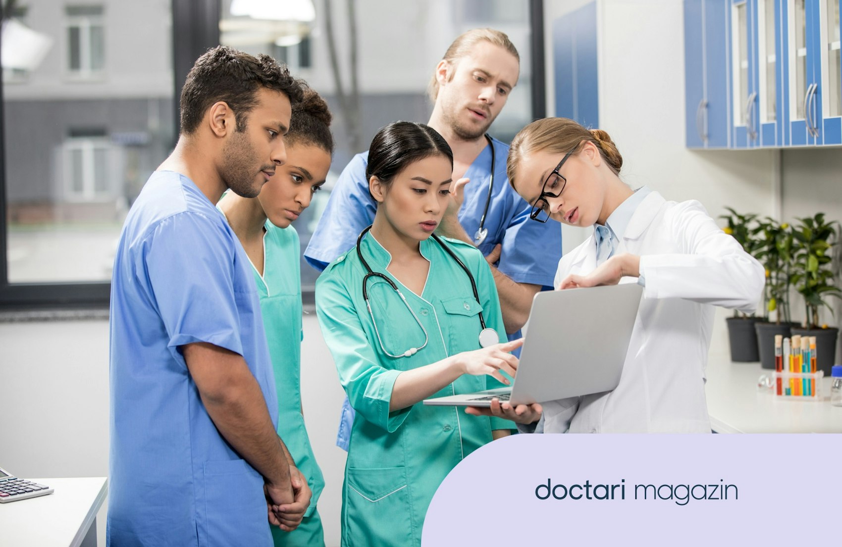 Eine Gruppe aus ÄrztInnen und Pflegekräften schaut gemeinsam in einen Laptop.