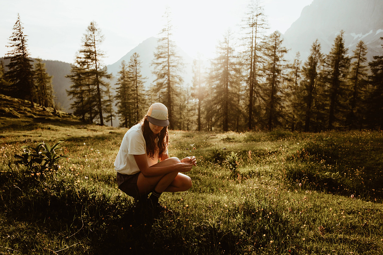 Foto ragazza nel bosco in Dolomiti raccoglie fiori sul prato