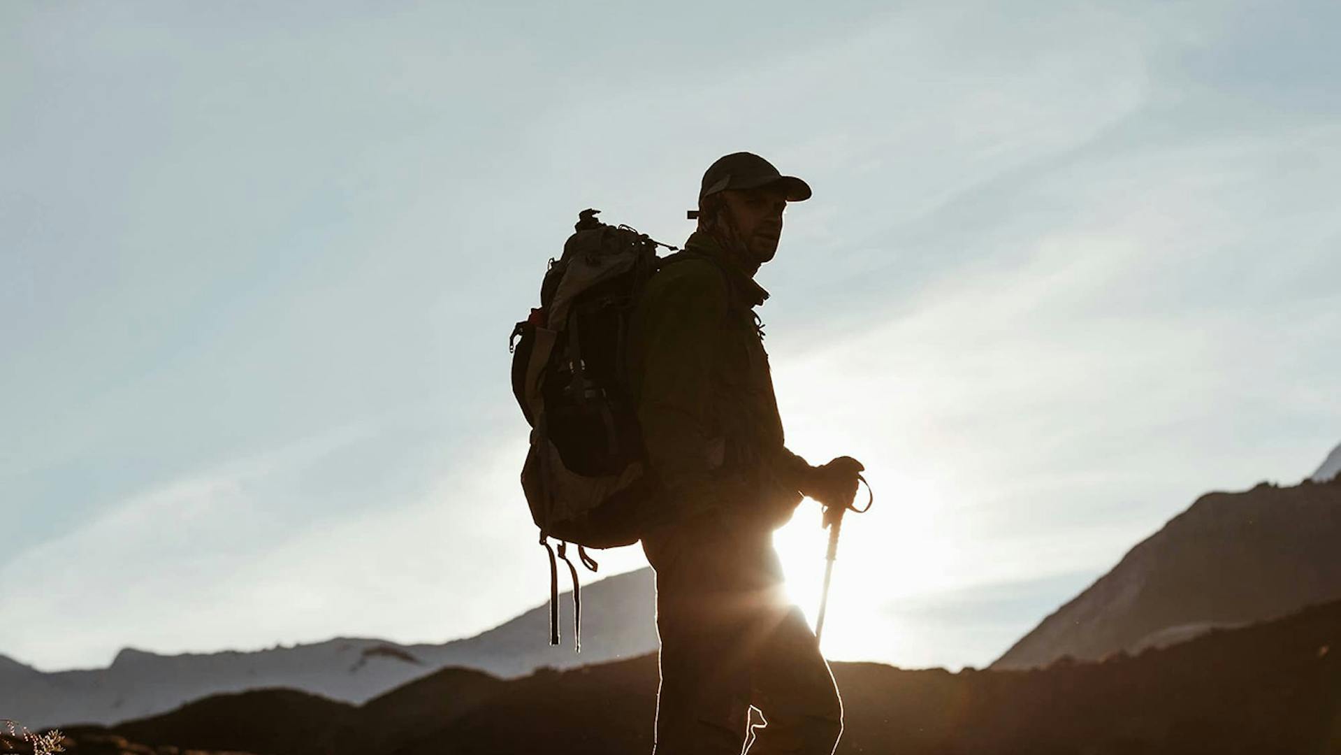 Foto uomo che fa trekking nelle Dolomiti al tramonto