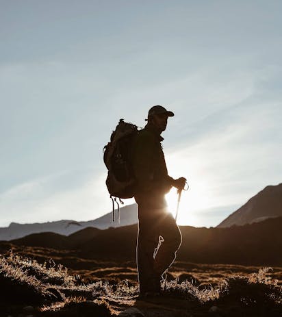 Foto uomo che fa trekking nelle Dolomiti al tramonto