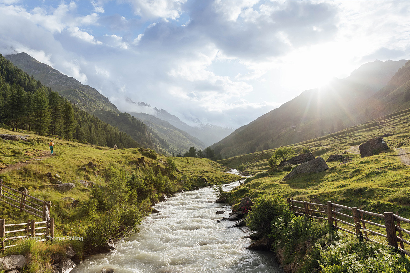 Passeggiata estiva al sole vicino al ruscello in Valle Aurina nelle Dolomiti dell'Alto Adige