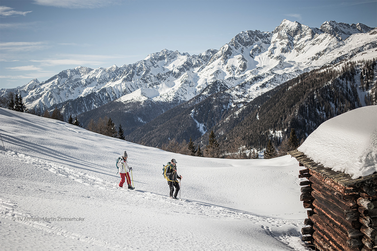 Due persone in un paesaggio innevato in Valle Aurina che fanno trekking invernale