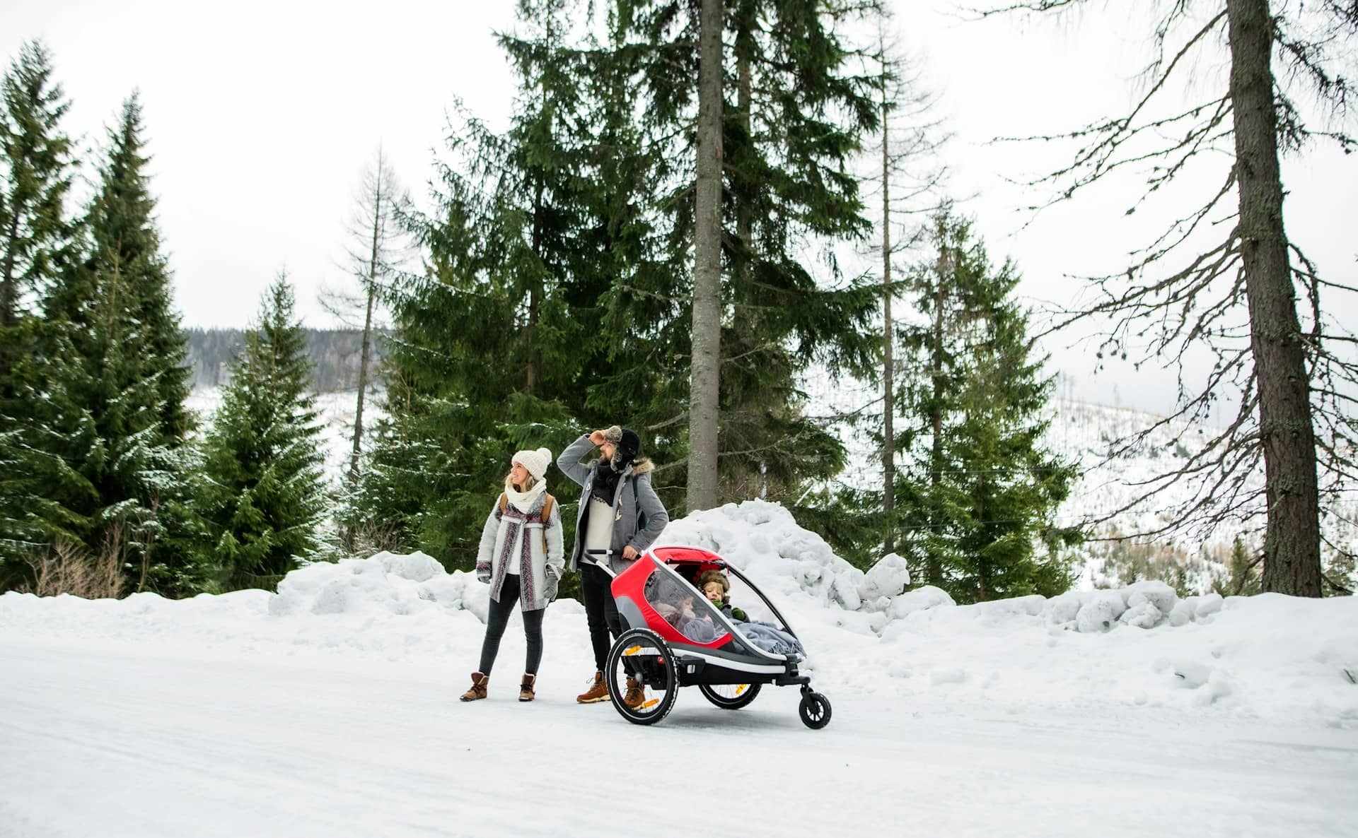 Famiglia con passeggino in paesaggio invernale dolomitico