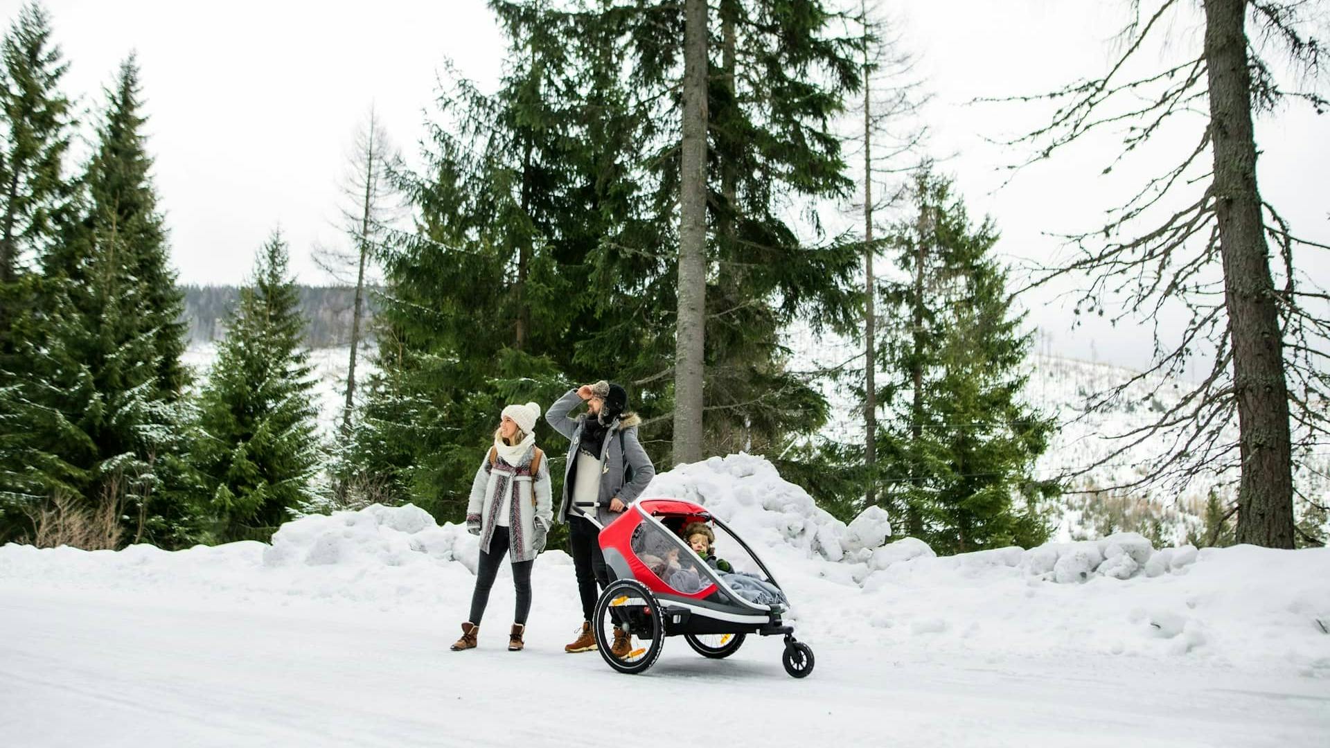 Famiglia con passeggino in paesaggio invernale dolomitico