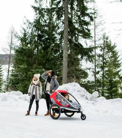 Famiglia con passeggino in paesaggio invernale dolomitico