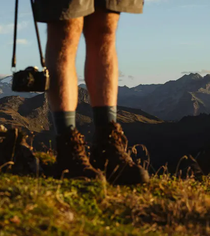 Scarponi da montagna e fotocamera per trekking in paesaggio dolomitico