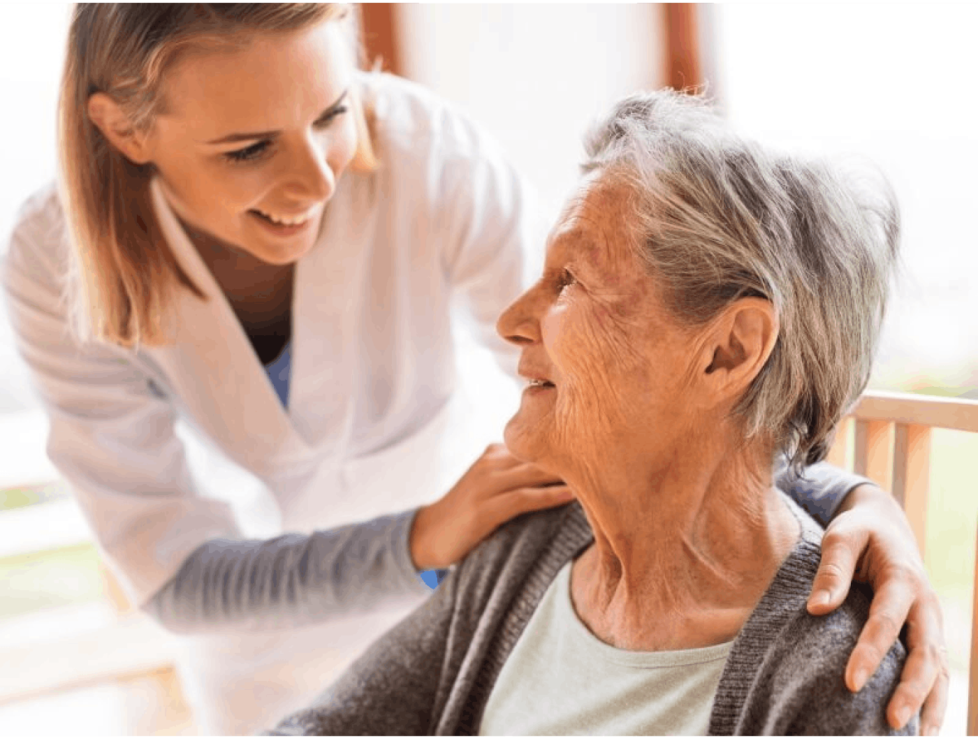 Betreuerin lacht mit älterer Frau