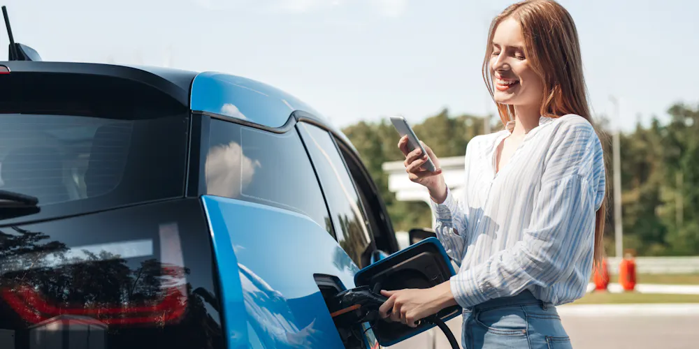 A woman charging an EV