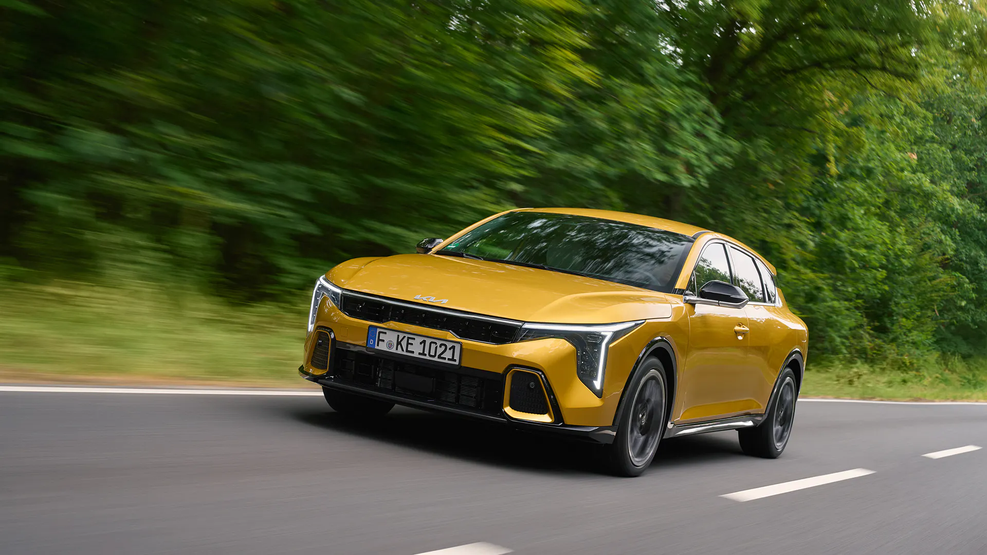 A Kia K4 driving on a road - Image 1