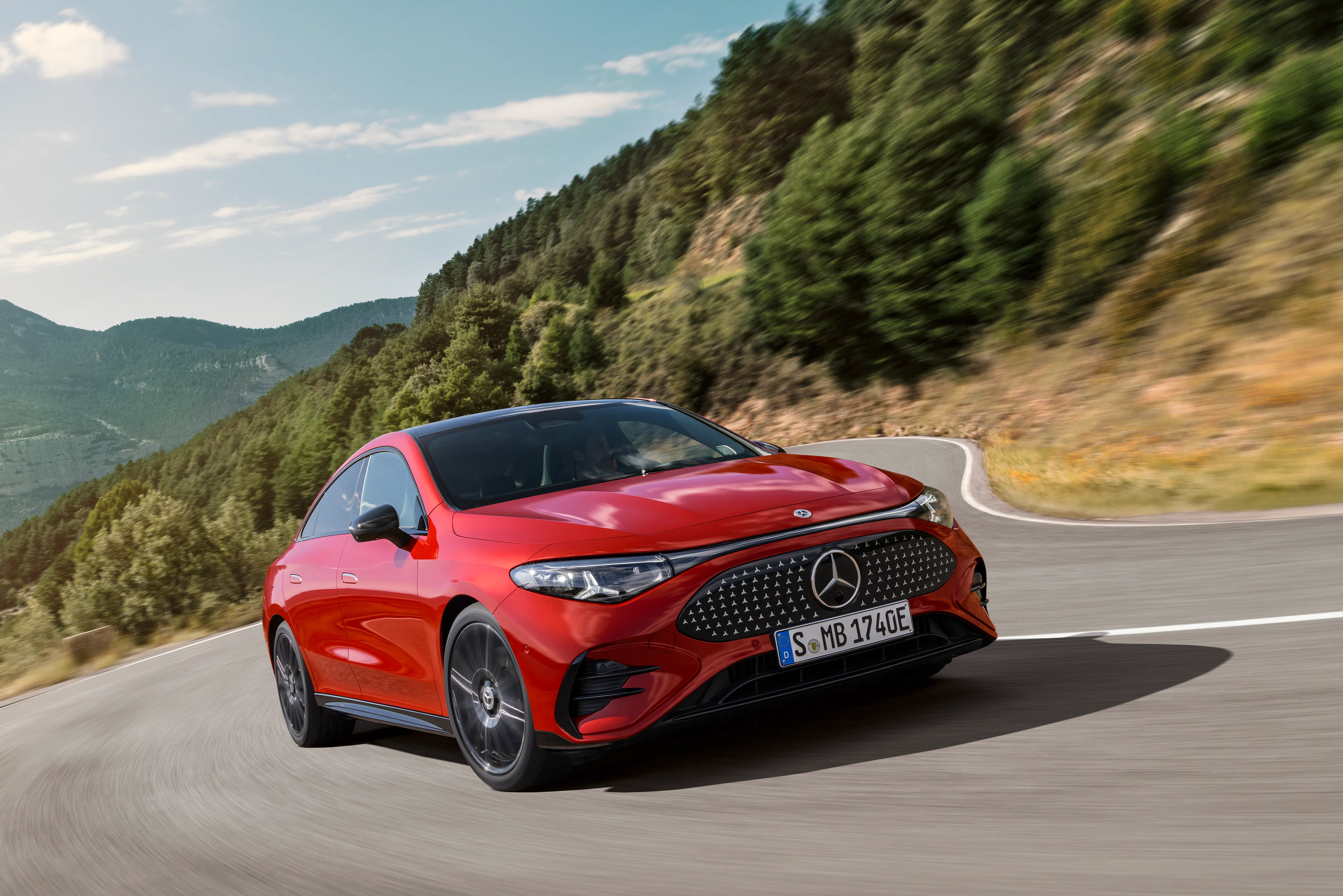 A red Mercedes CLA driving on a country road - Image 1
