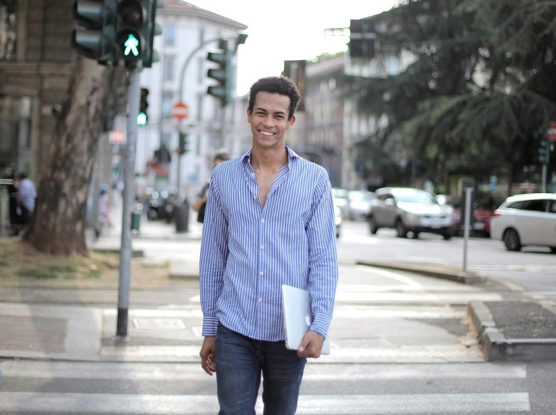 Person smiling walking down a street