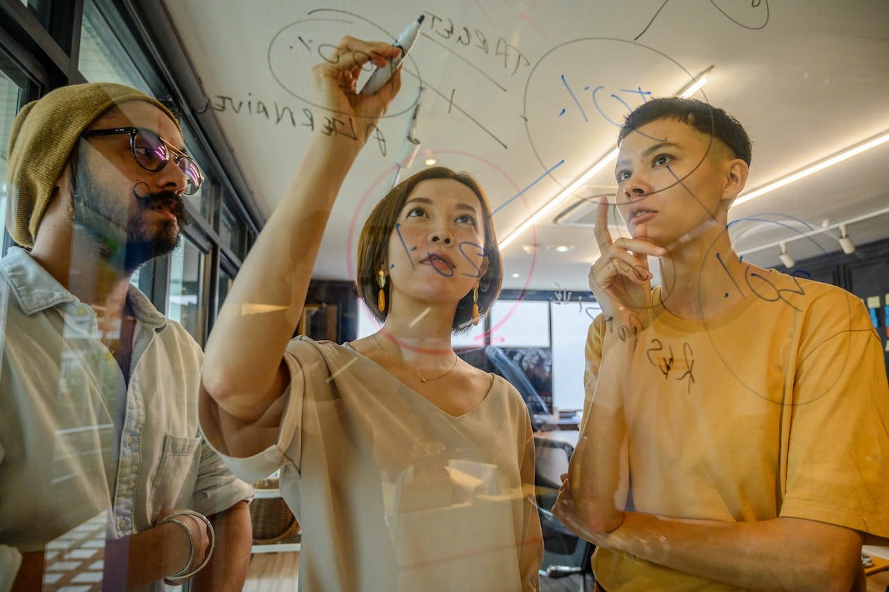 People analyzing information on transparent board