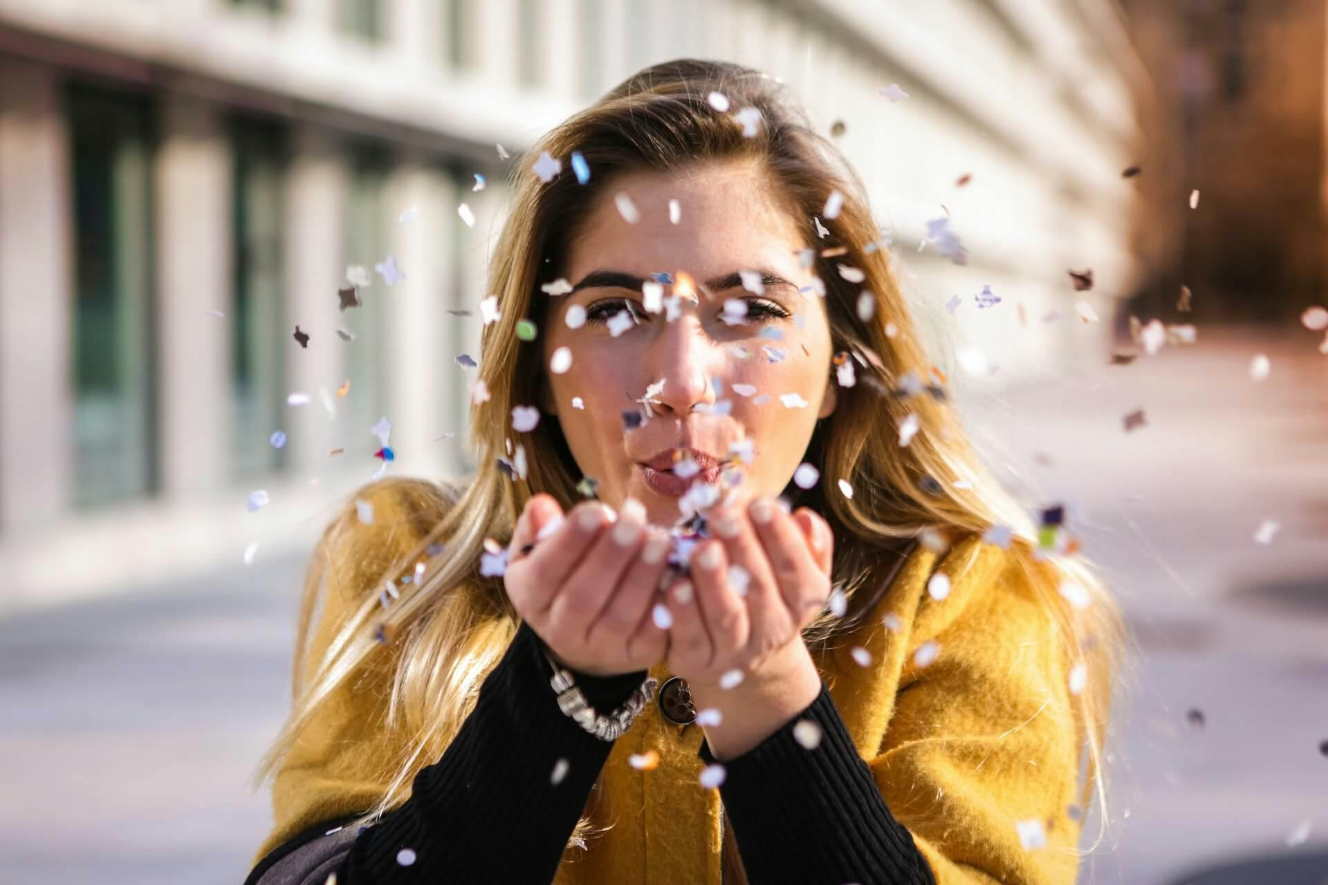 Woman blowing confetti