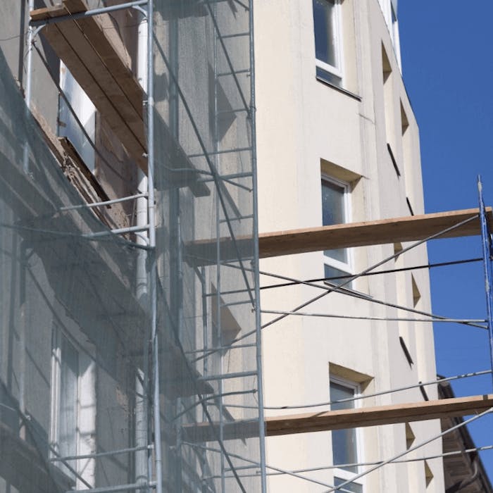 Fassade eines Mehrfamilienhauses mit Gerüst davor