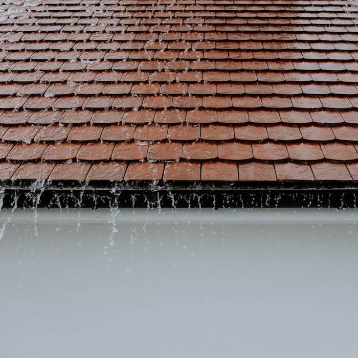 Wasser läuft von Hausdach