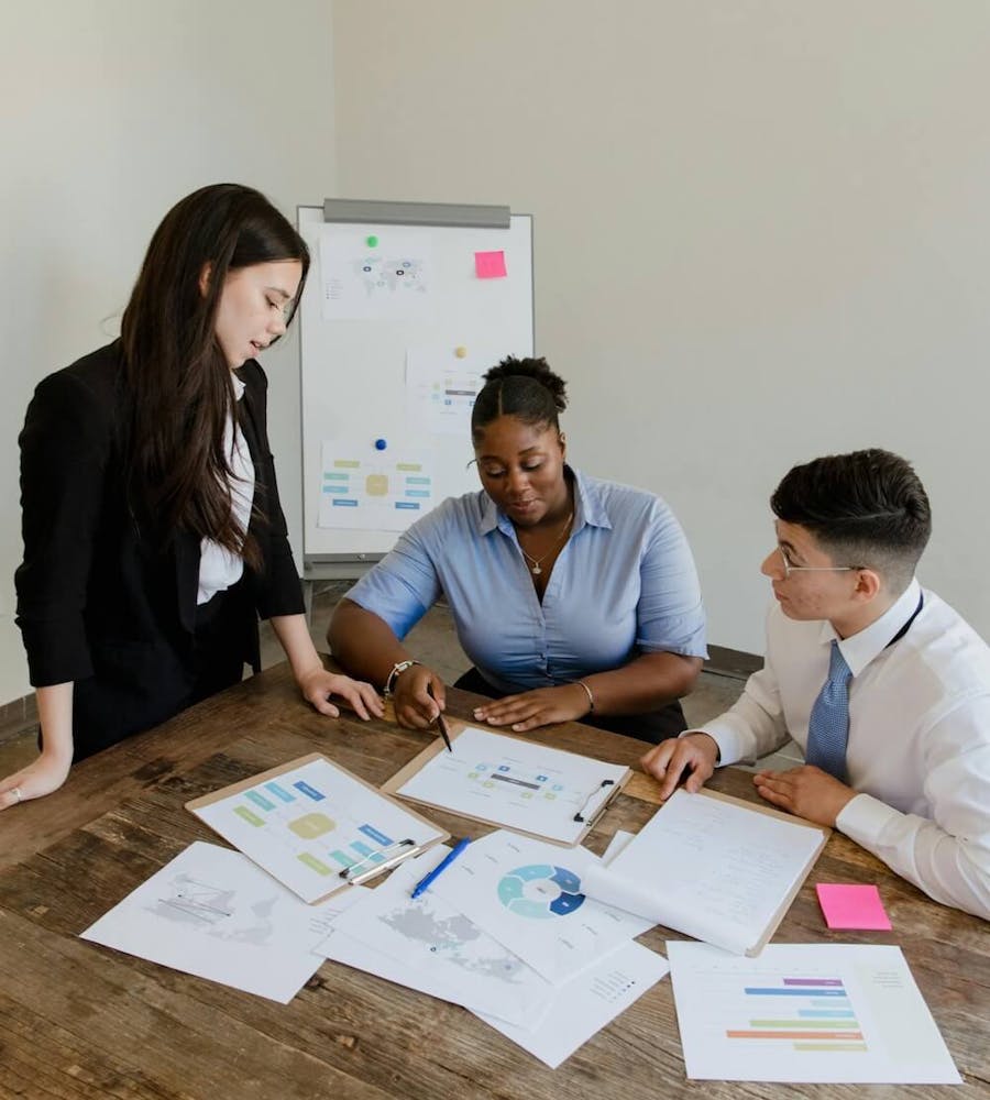 Drei Personen sitzen am Tisch und sprechen über Auswertungen