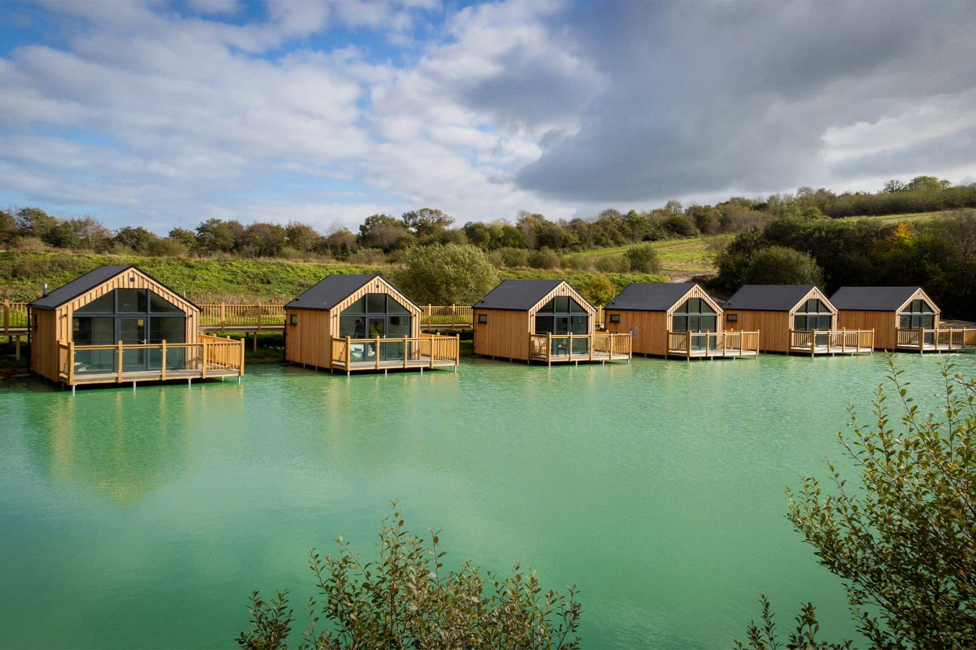 Hoseasons resort with six cabins on a lake with hills in the background