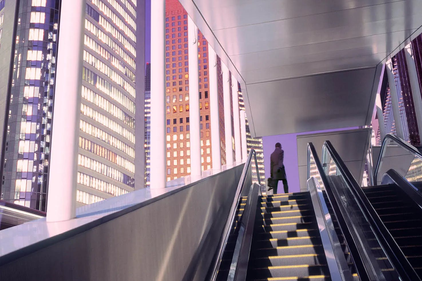 Inside building with 2 escalators in front with man at top