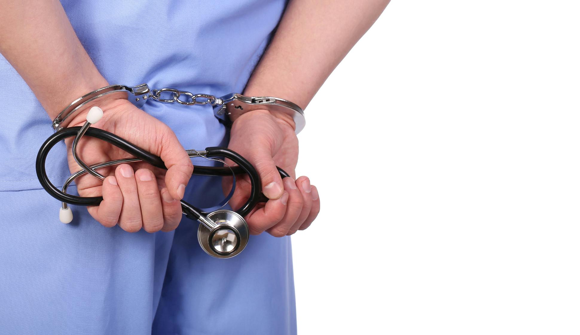 A doctor in handcuffs with a stethoskop in his hands