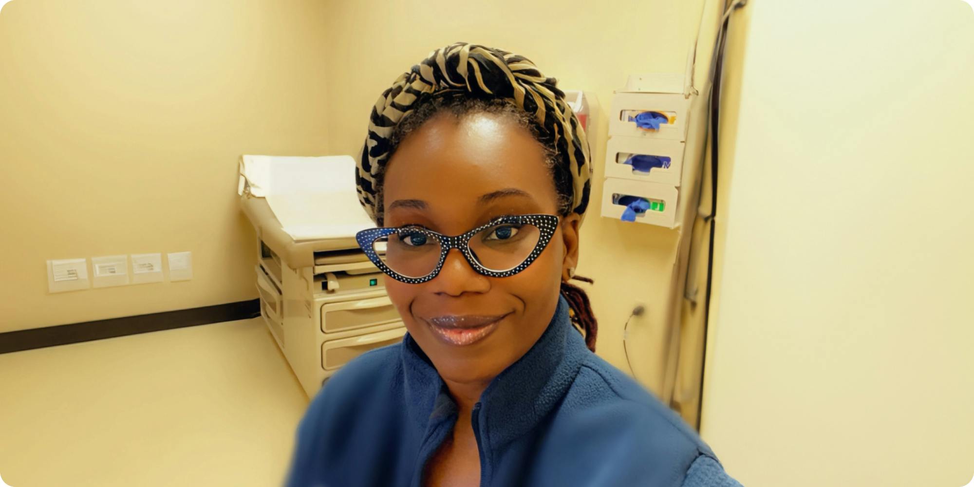 Nurse Asiyah Franklin smiling in front of a consult room in a health clinic