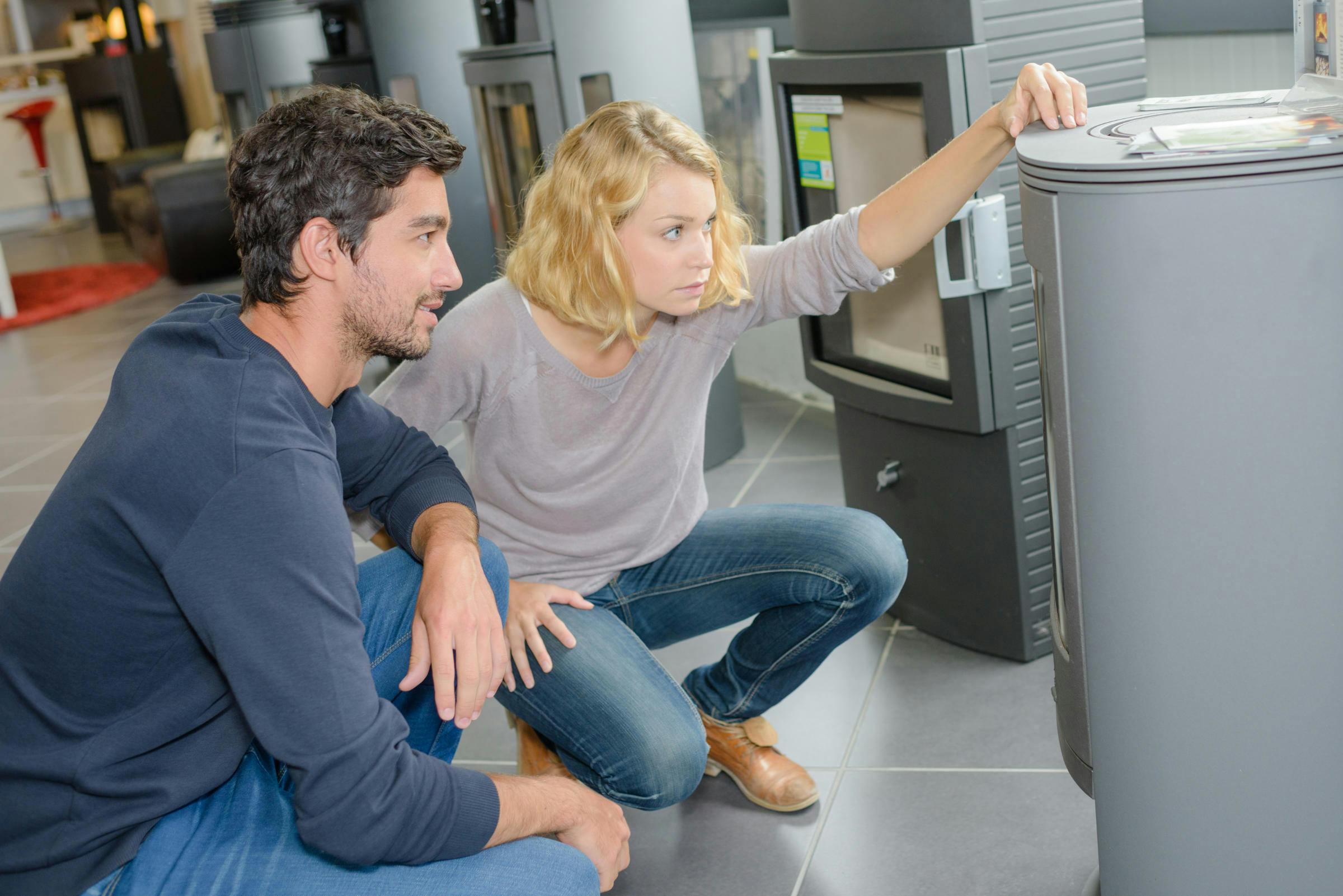 Man and woman looking at a heating unit