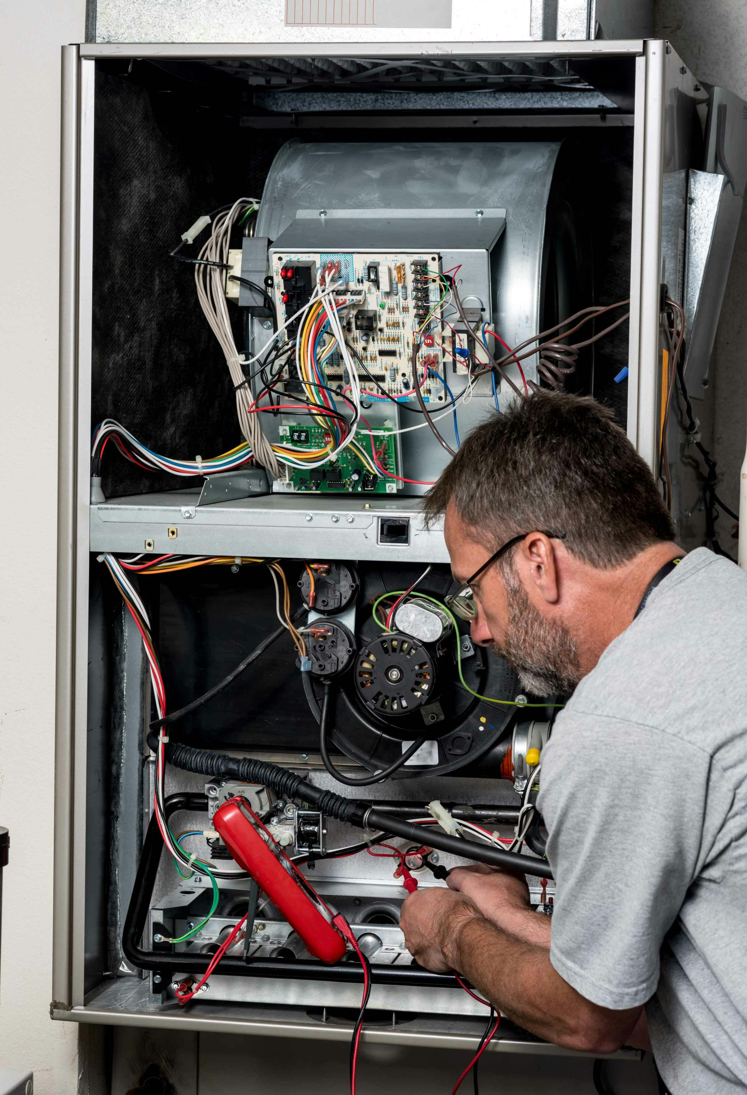 Service technician troubleshooting high-efficient furnace
