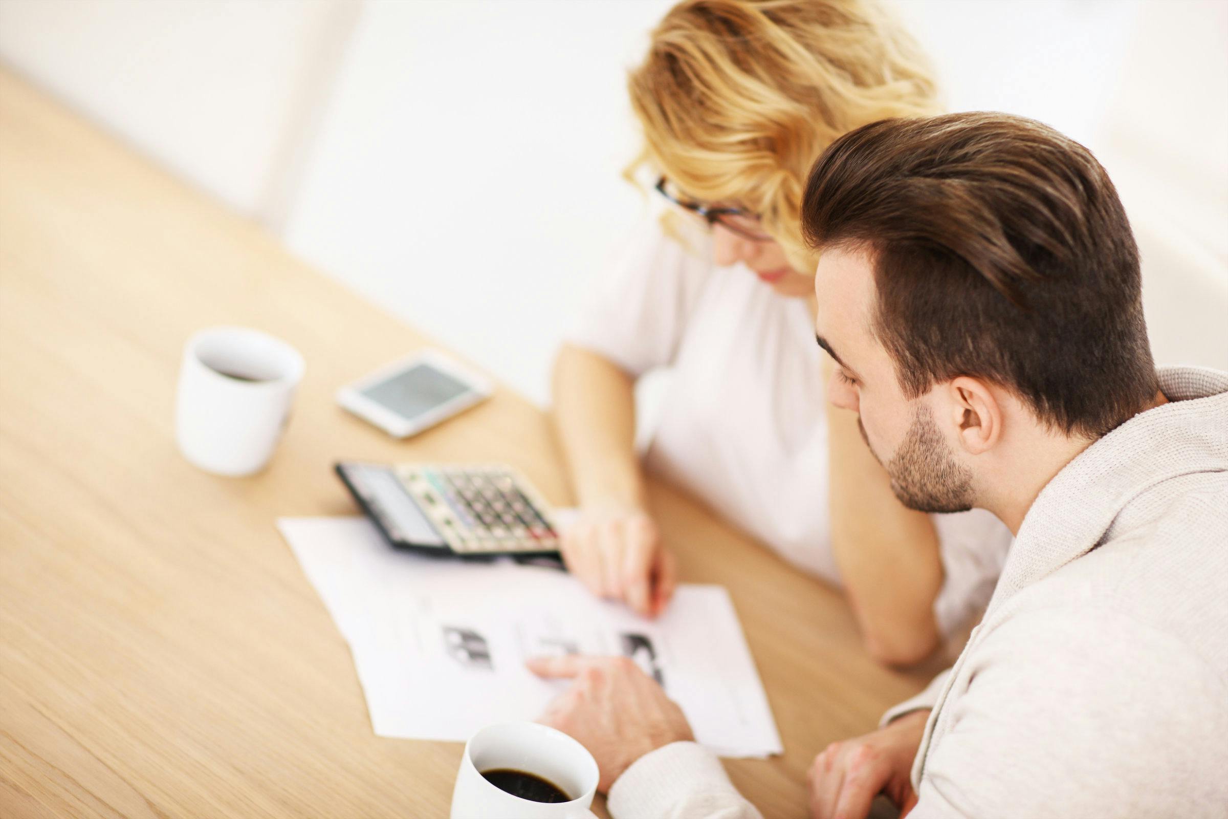 Couple looking at financial sheet with a calculator