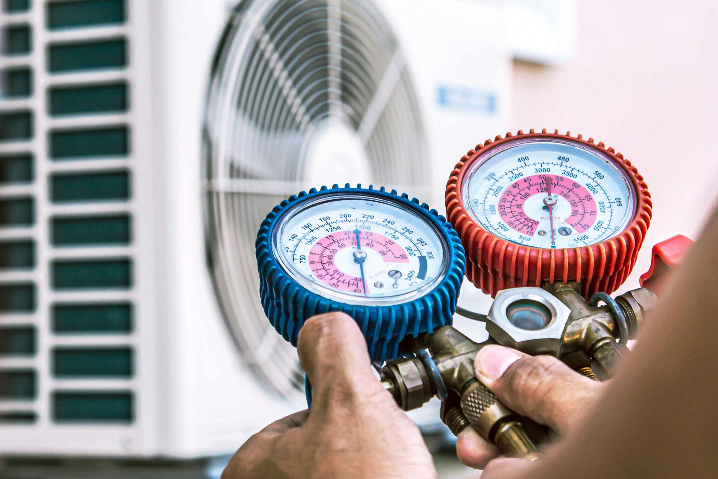Service tech reading refrigeration gauges
