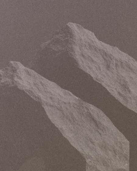 Mynd af kletti á brúnum bakgrunni.