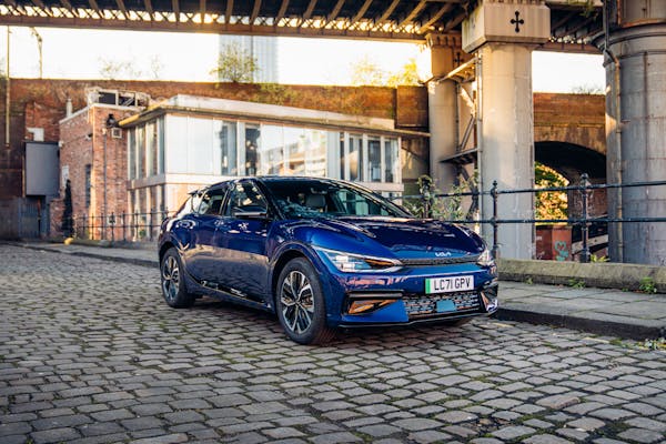 Blue Kia EV6 electric car on cobbled city street