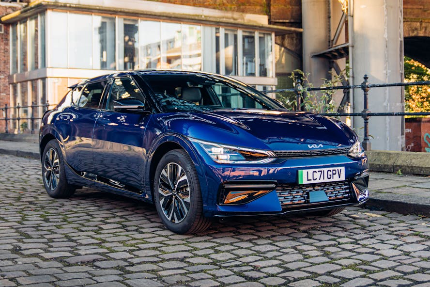 Blue Kia EV6 electric car on cobbled city street