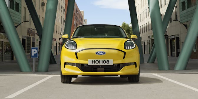 Ford Puma Gen e yellow electric car head on under bridge