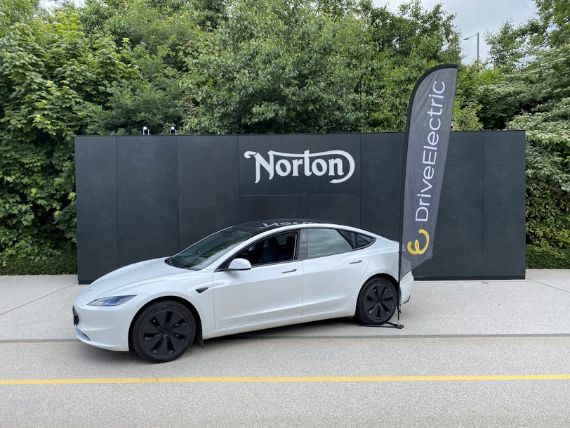 A white Tesla Model 3 parked outside Norton Motorcycles HQ in Solihull, UK