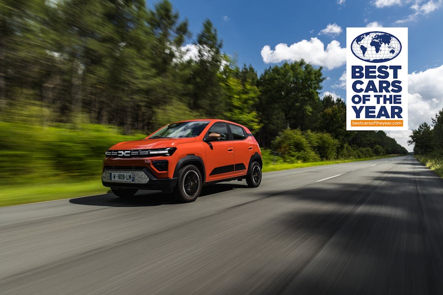 Dacia Spring - orange Electric Car driving on forest road 