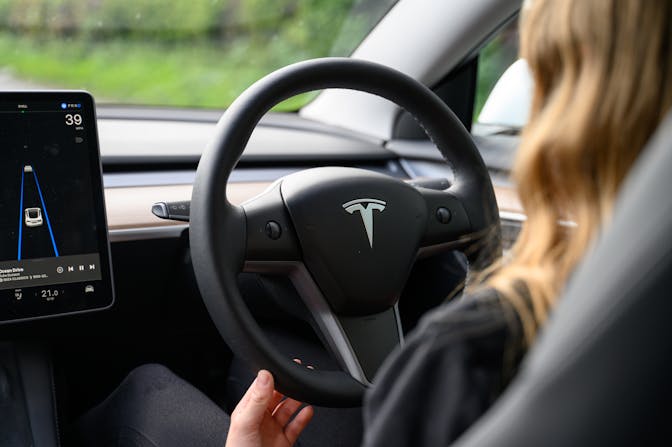 Woman sitting behind the wheel of a Tesla electric car