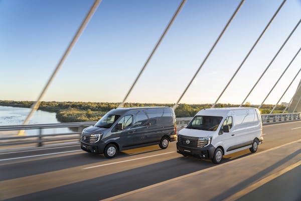 2 nissan interstar electric vans driving on bridge  side view
