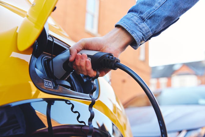 Plugging in a Yellow electric vehicle to charge 