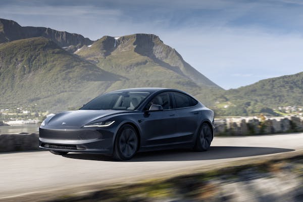 Tesla model 3 electric car with scenic mountain background