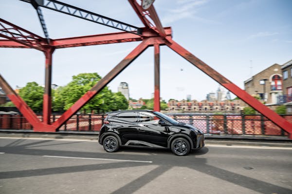 BYD dolphin surf electric car driving on red bridge 