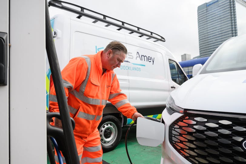 Keolis Amey Docklands team member plugging an electric van in to charge