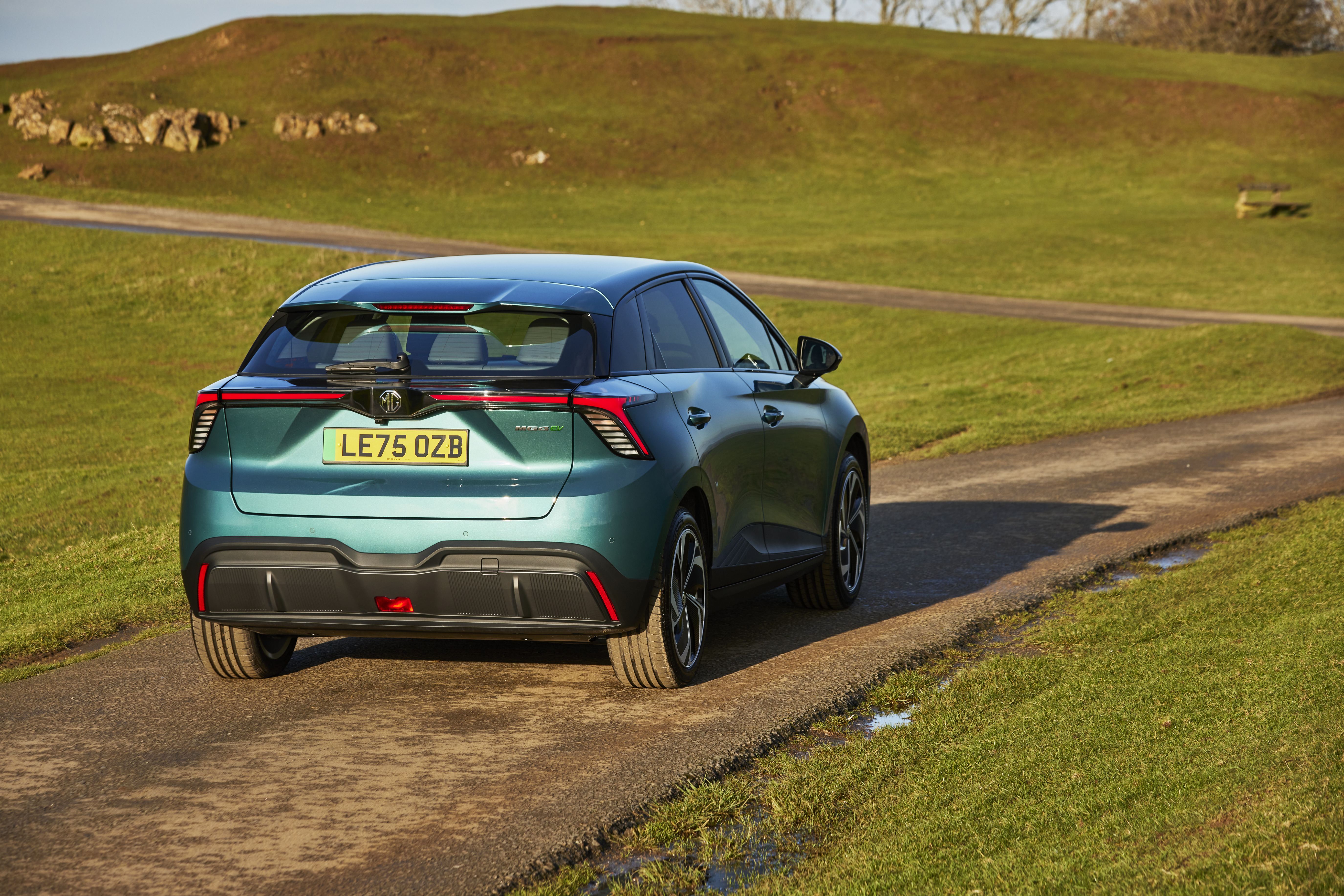 MG 4 2026 updated Electric car driving through fields  - rear view 