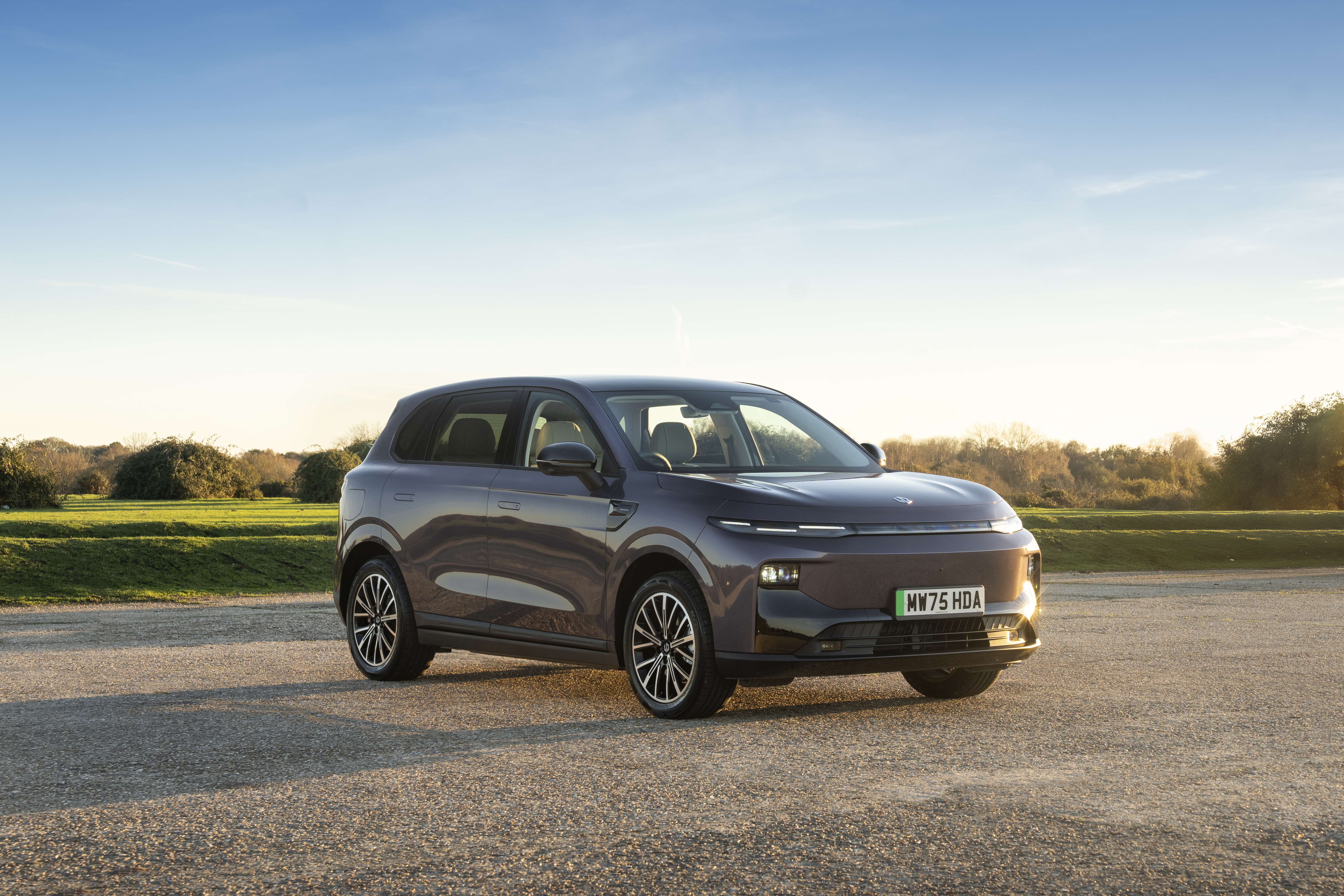 Leapmotor electric car front view, in car park with green field behind
