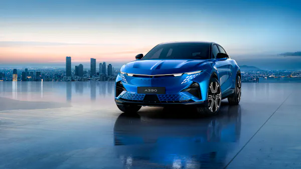 Alpine A390 electric car in blue with city sky line in the distance