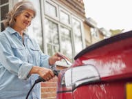 Woman charging car outside her home