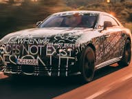 All electric rolls royce spectre driving in sunset