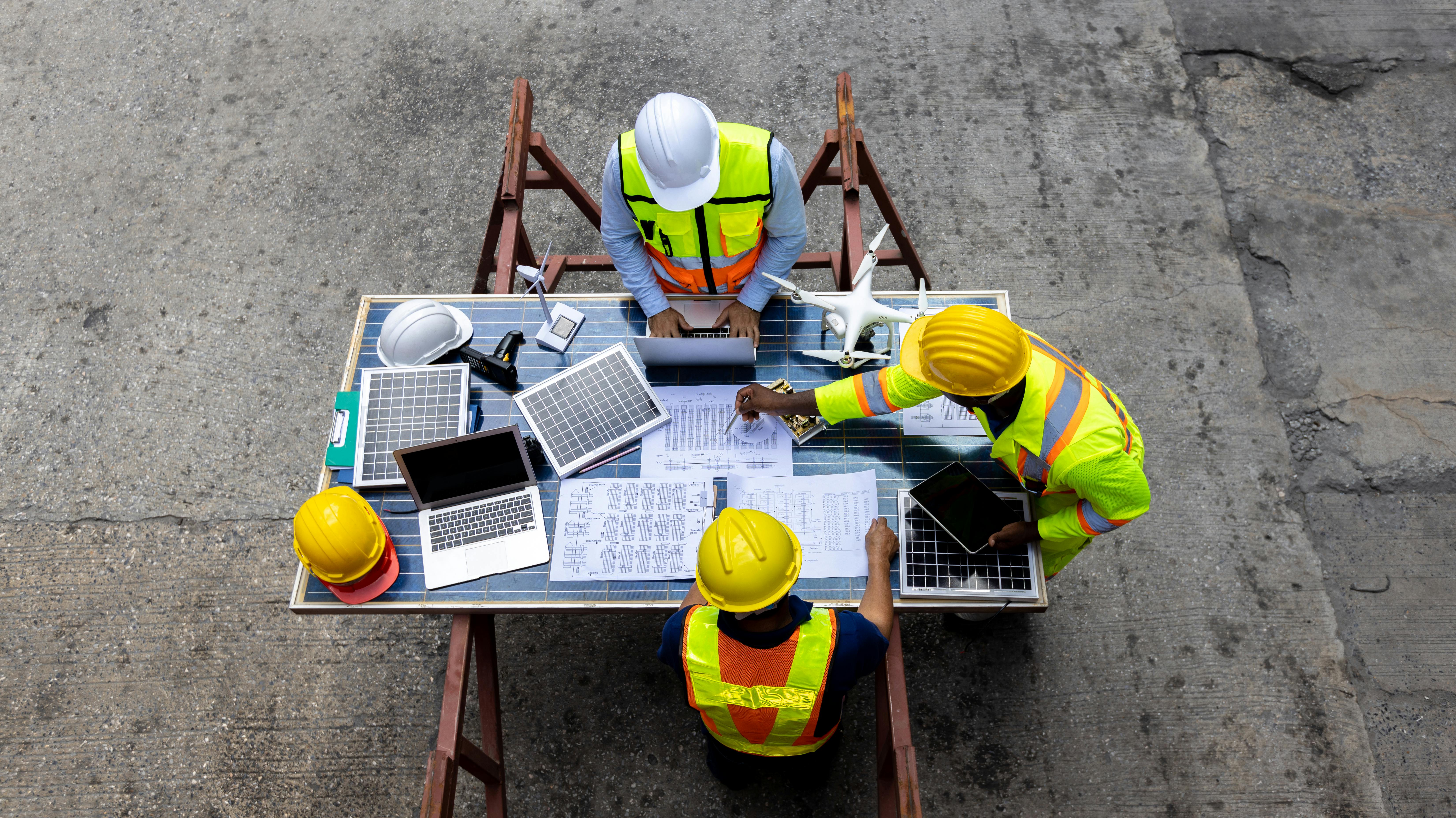 Group of construction workers planning with a drone
