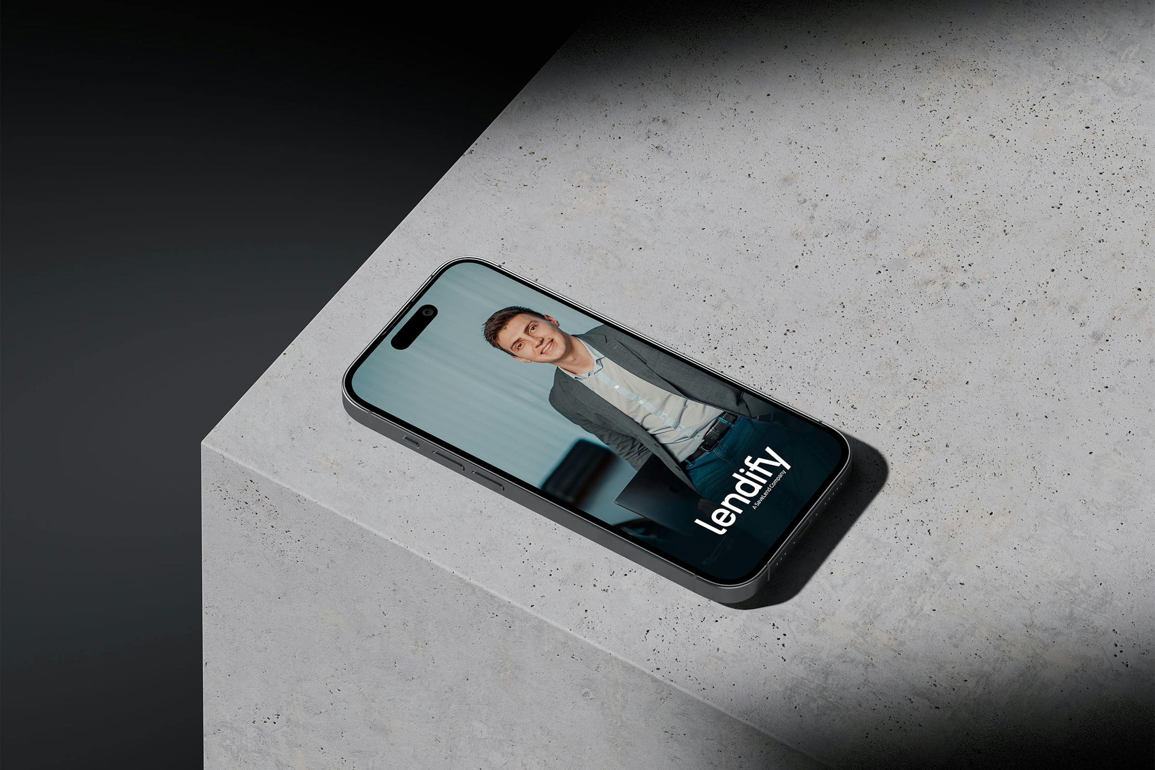 An iPhone sitting on a concrete surface displaying an Lendify ad